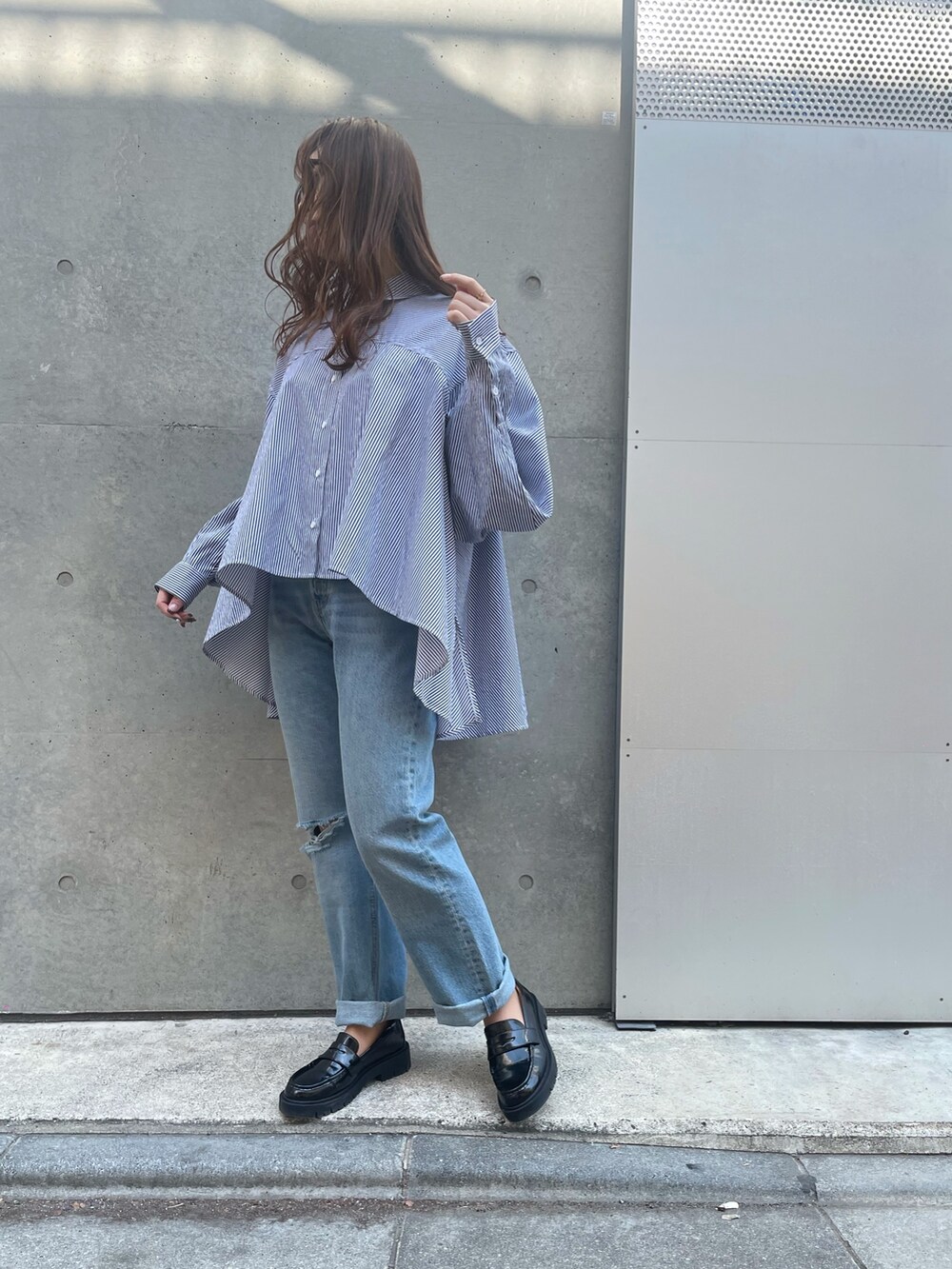 ブルー系のデニムパンツ、ブラック系のローファー、ブラック系のベストを着用したレディースの春コーディネートの6枚目の写真