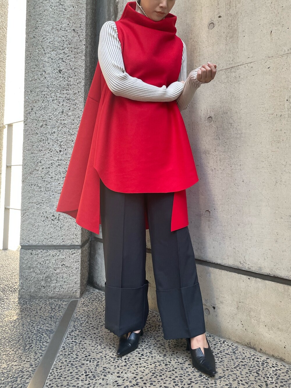 レッド系のベスト、ホワイト系のニット/セーター、ブラック系のその他パンツを着用したレディースの秋コーディネートの3枚目の写真