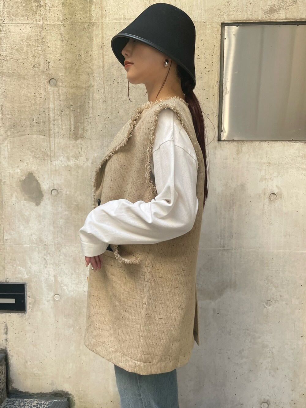 ベージュ系のベスト、ブラック系のハットを着用したレディースの冬コーディネートの8枚目の写真