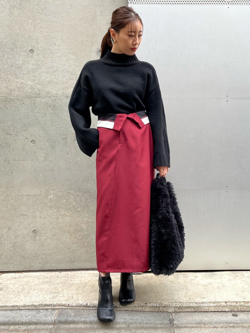 ブラック系のブーツ、レッド系のスカート、ブラック系のニット/セーターを着用したレディースの冬コーディネートの5枚目の写真