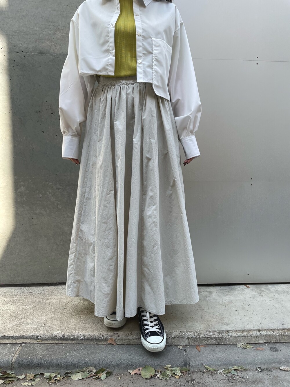 ブラック系のスニーカー、グレー系のスカート、ホワイト系のシャツ/ブラウスを着用したレディースの春コーディネートの4枚目の写真