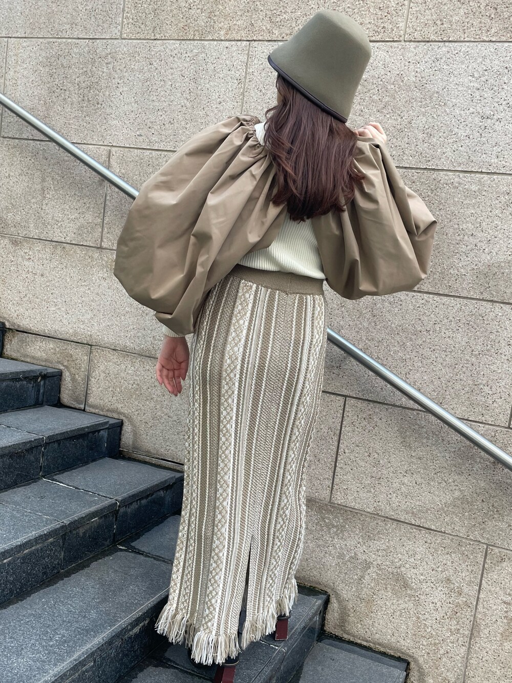 ベージュ系のスカート、ブラウン系のカーディガン/ボレロ、グリーン系のハットを着用したレディースの秋コーディネートの5枚目の写真