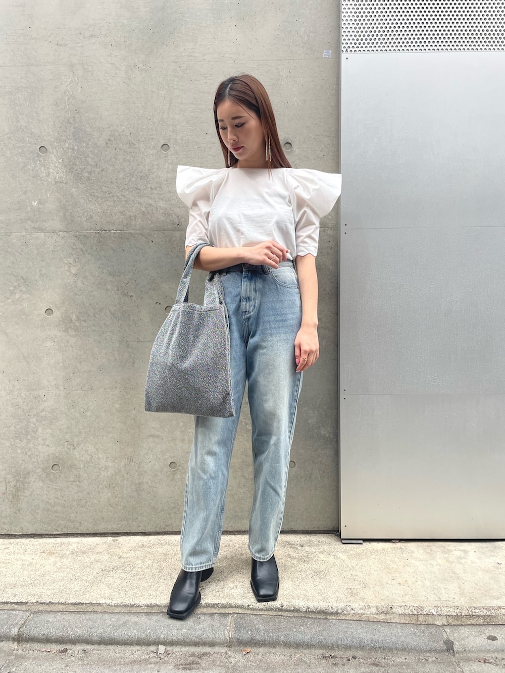 ホワイト系のTシャツ/カットソー、シルバー系のトートバッグ、ブルー系のデニムパンツを着用したレディースの春コーディネートの2枚目の写真
