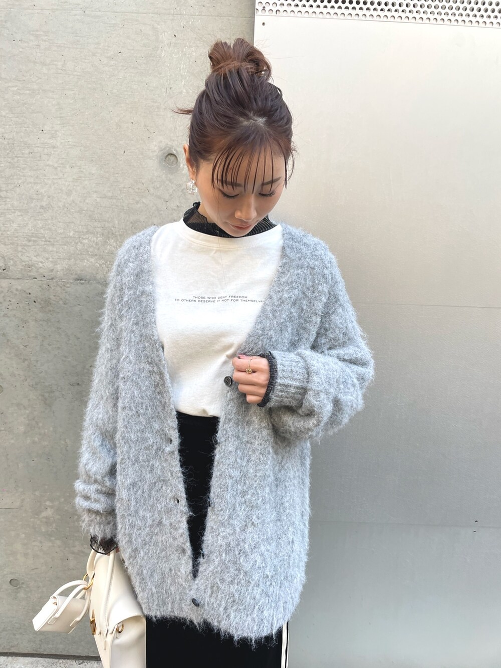 ブラック系のTシャツ/カットソー、グレー系のカーディガン/ボレロ、ブラック系のスカートを着用したレディースの冬コーディネートの2枚目の写真