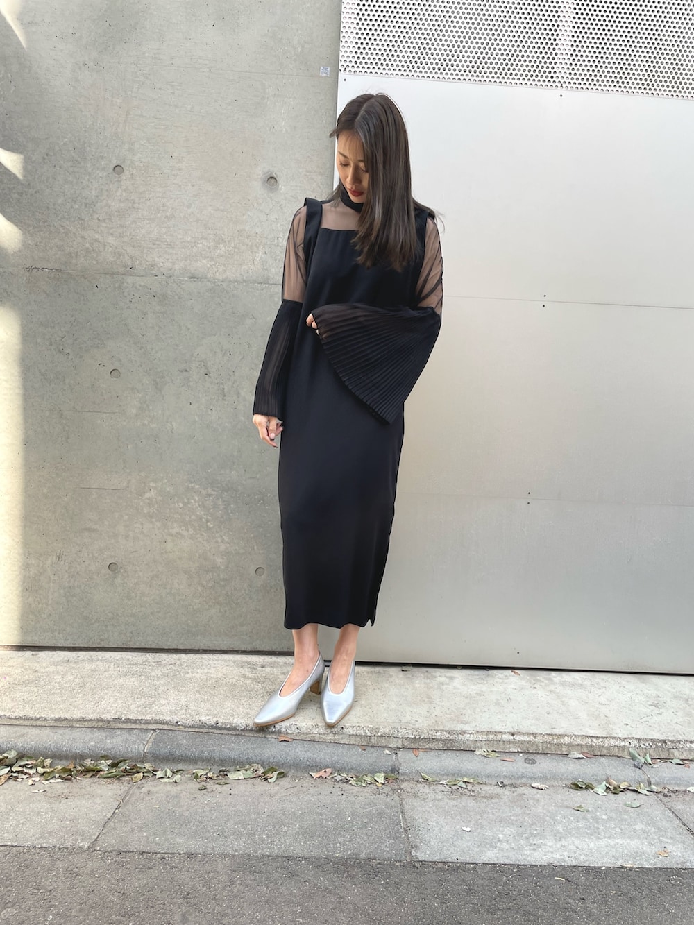 ブラック系のワンピース、シルバー系のパンプスを着用したレディースの春コーディネートの2枚目の写真