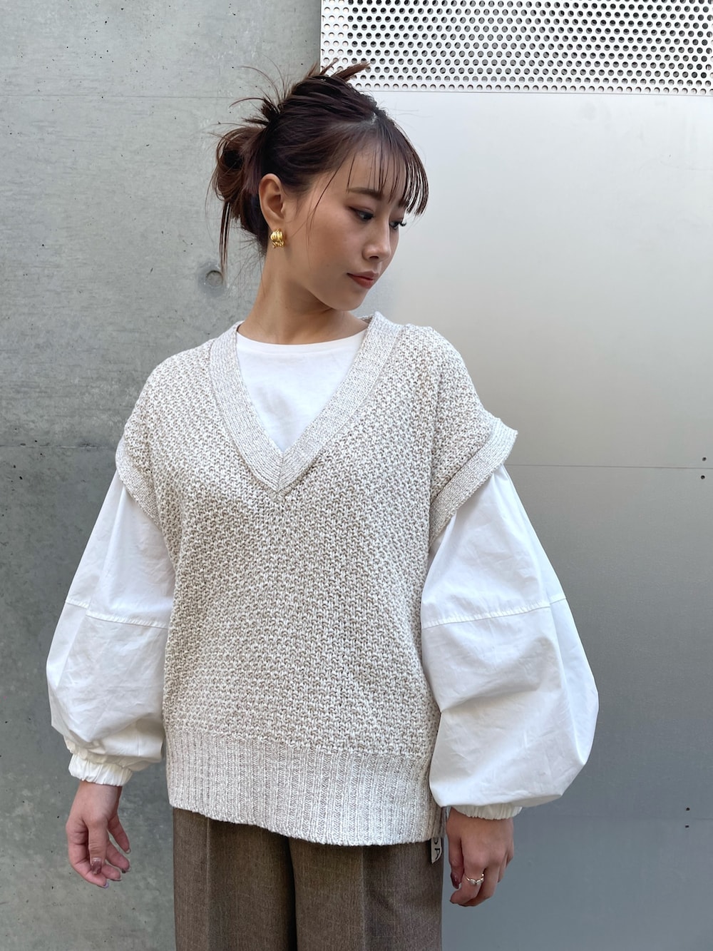 ホワイト系のTシャツ/カットソー、ホワイト系のベスト、ブラウン系のパンツを着用したレディースの冬コーディネートの3枚目の写真