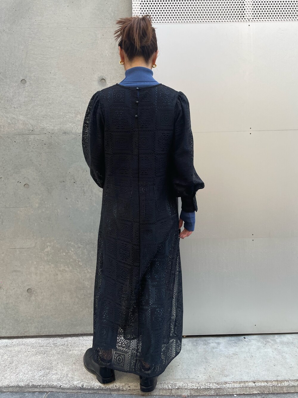 ブラック系のデニムジャケット、ブルー系のニット/セーター、ブラック系のワンピースを着用したレディースの冬コーディネートの6枚目の写真