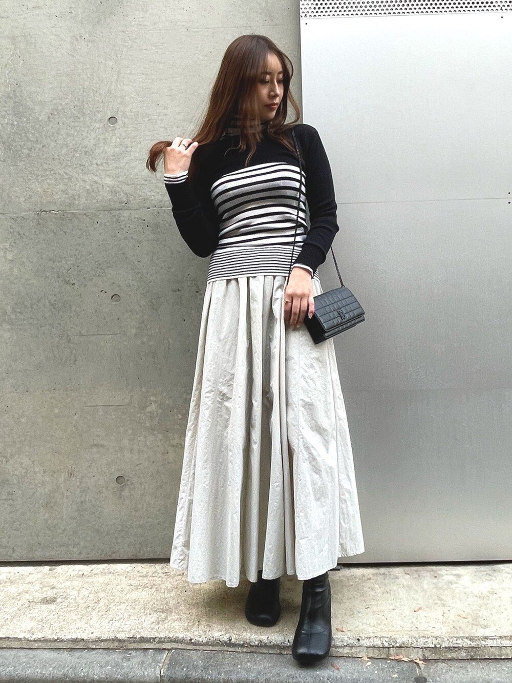 ブラック系のニット/セーター、ホワイト系のニット/セーター、グレー系のスカートを着用したレディースの冬コーディネートの4枚目の写真