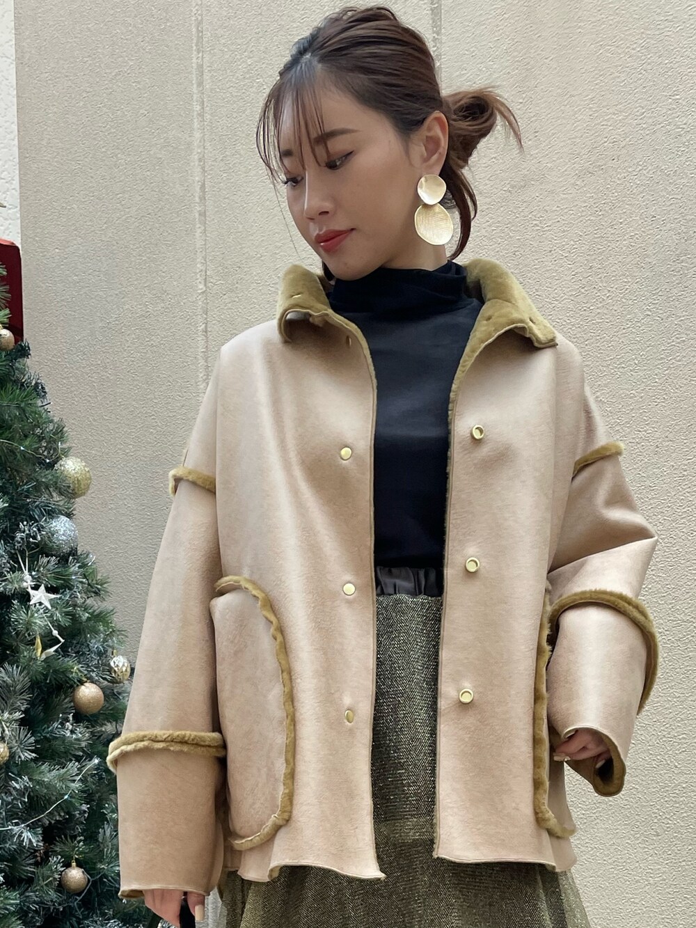 ゴールド系のスカート、ブラック系のショルダーバッグ、ブラック系のTシャツ/カットソーを着用したレディースの冬コーディネートの7枚目の写真