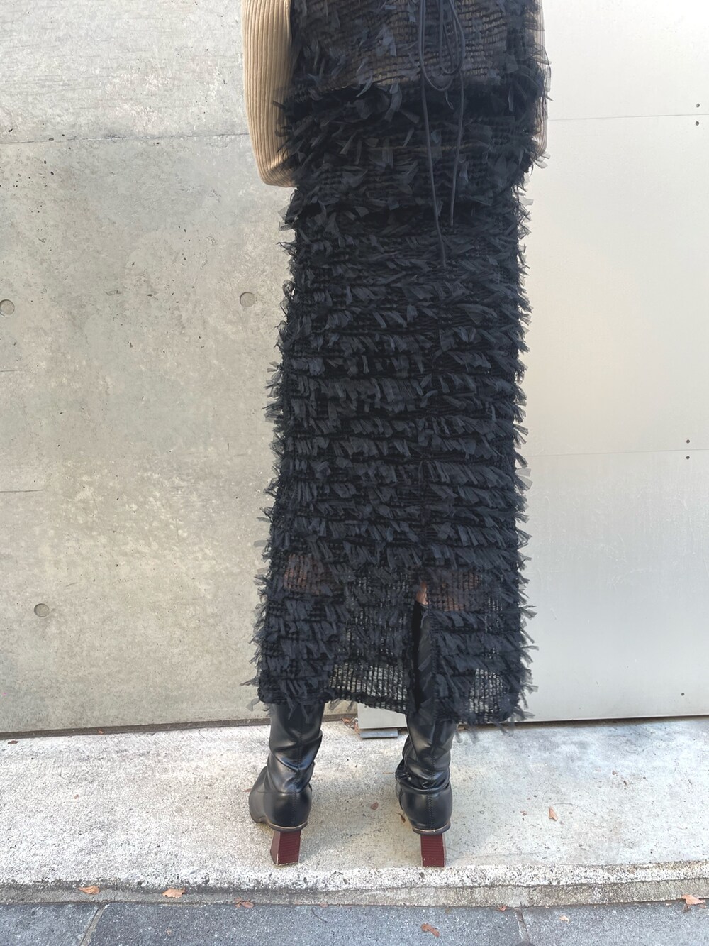 ベージュ系のニット/セーター、ブラック系のベスト、ブラック系のスカートを着用したレディースの冬コーディネートの6枚目の写真