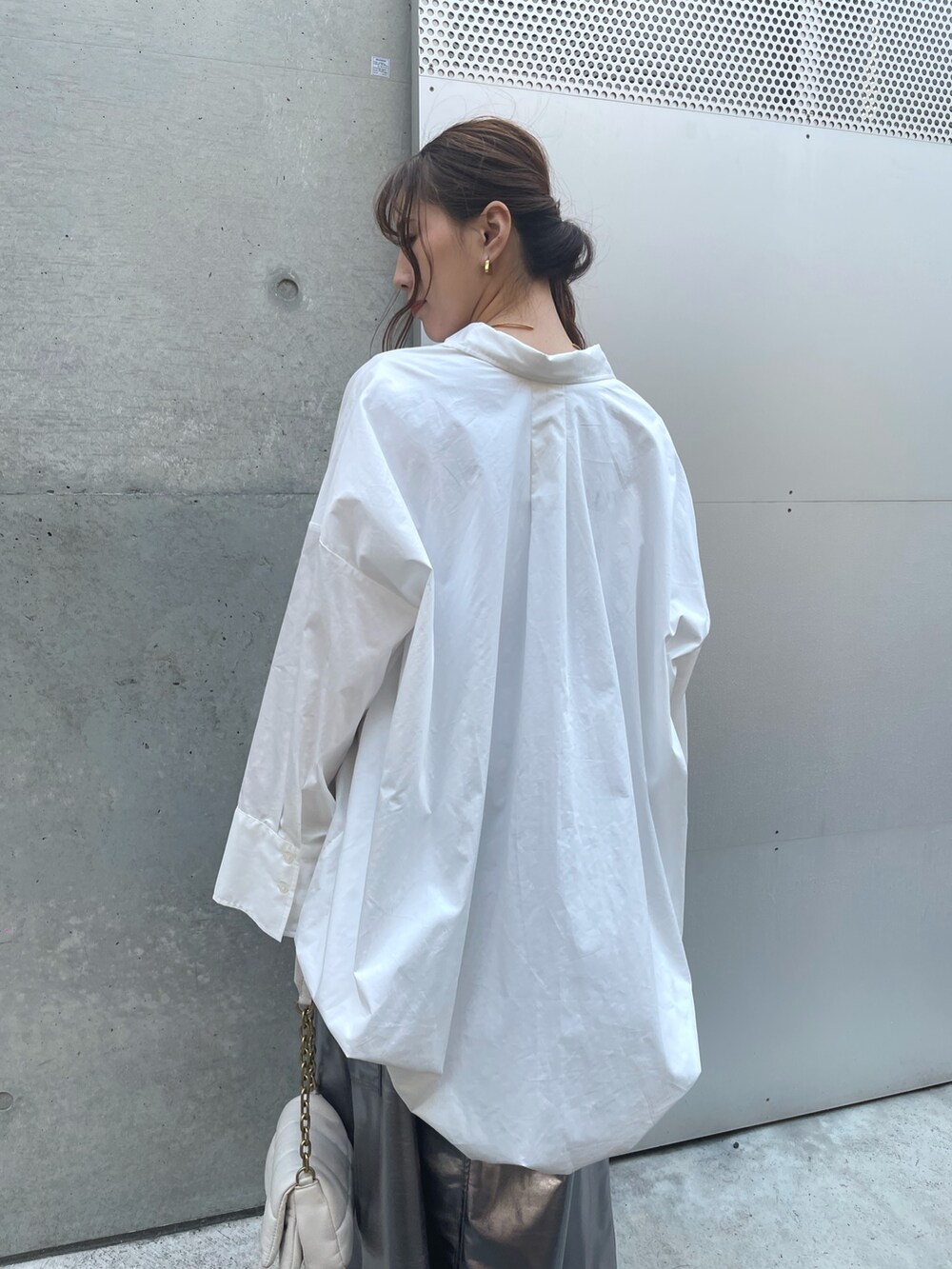 ホワイト系のスニーカー、ホワイト系のバッグ、シルバー系のスカートを着用したレディースの春コーディネートの5枚目の写真