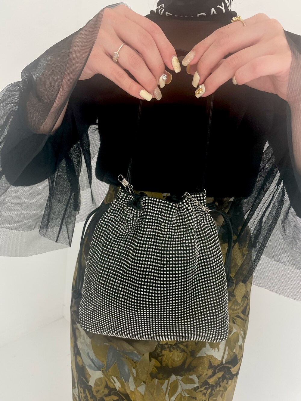 ブラック系のトートバッグ、ホワイト系のスカートを着用したレディースの冬コーディネートの7枚目の写真