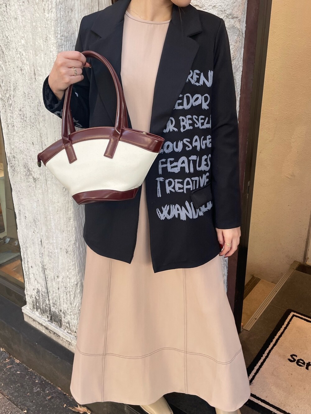 ベージュ系のワンピース、ブラウン系のハンドバッグ、ブラック系のサングラスを着用したレディースの秋コーディネートの6枚目の写真