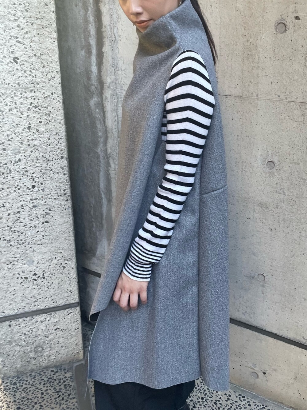 グレー系のベスト、ホワイト系のニット/セーターを着用したレディースの秋コーディネートの9枚目の写真