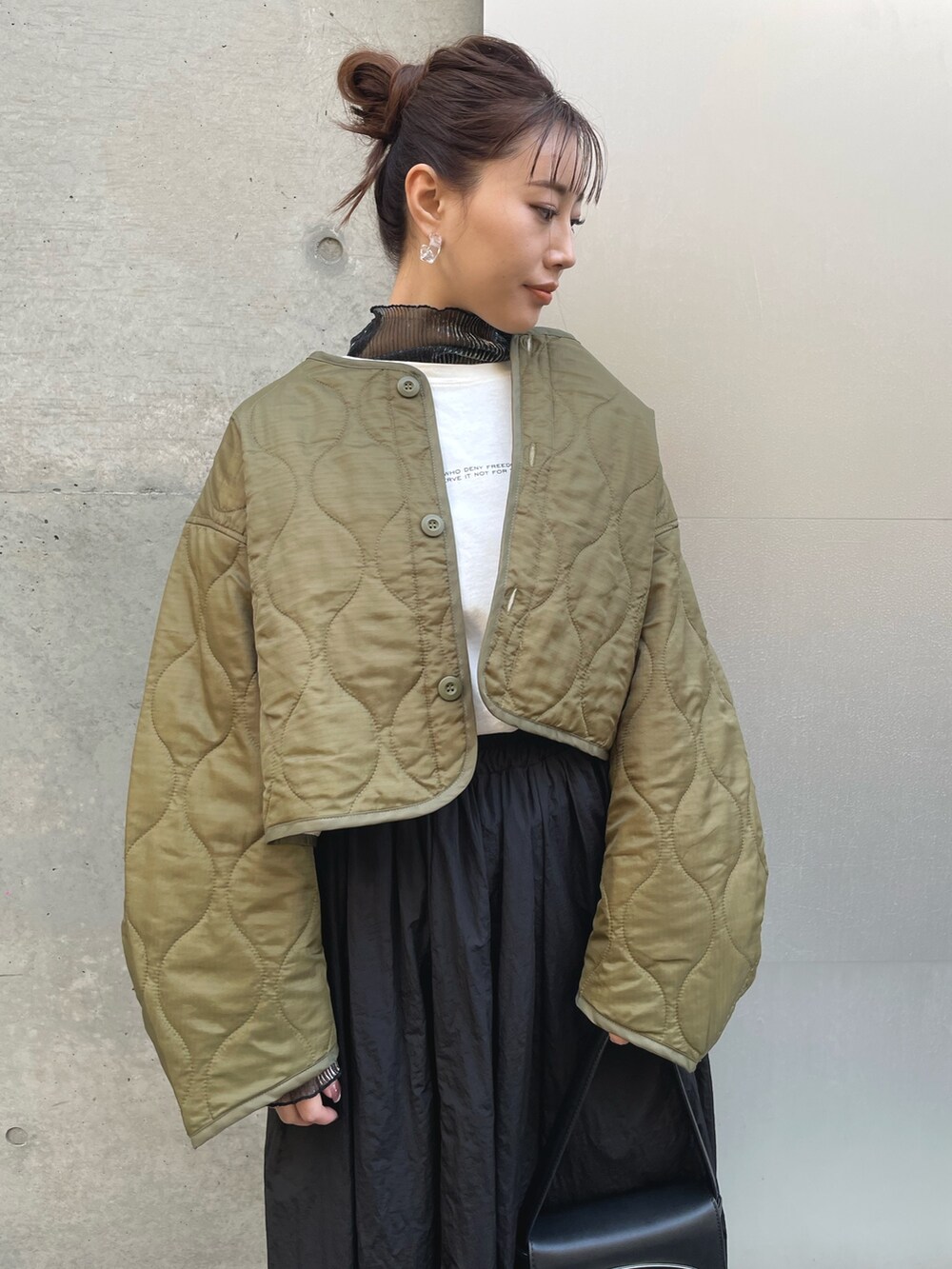 グリーン系のその他アウター、ブラック系のTシャツ/カットソー、ブラック系のスカートを着用したレディースの冬コーディネートの2枚目の写真