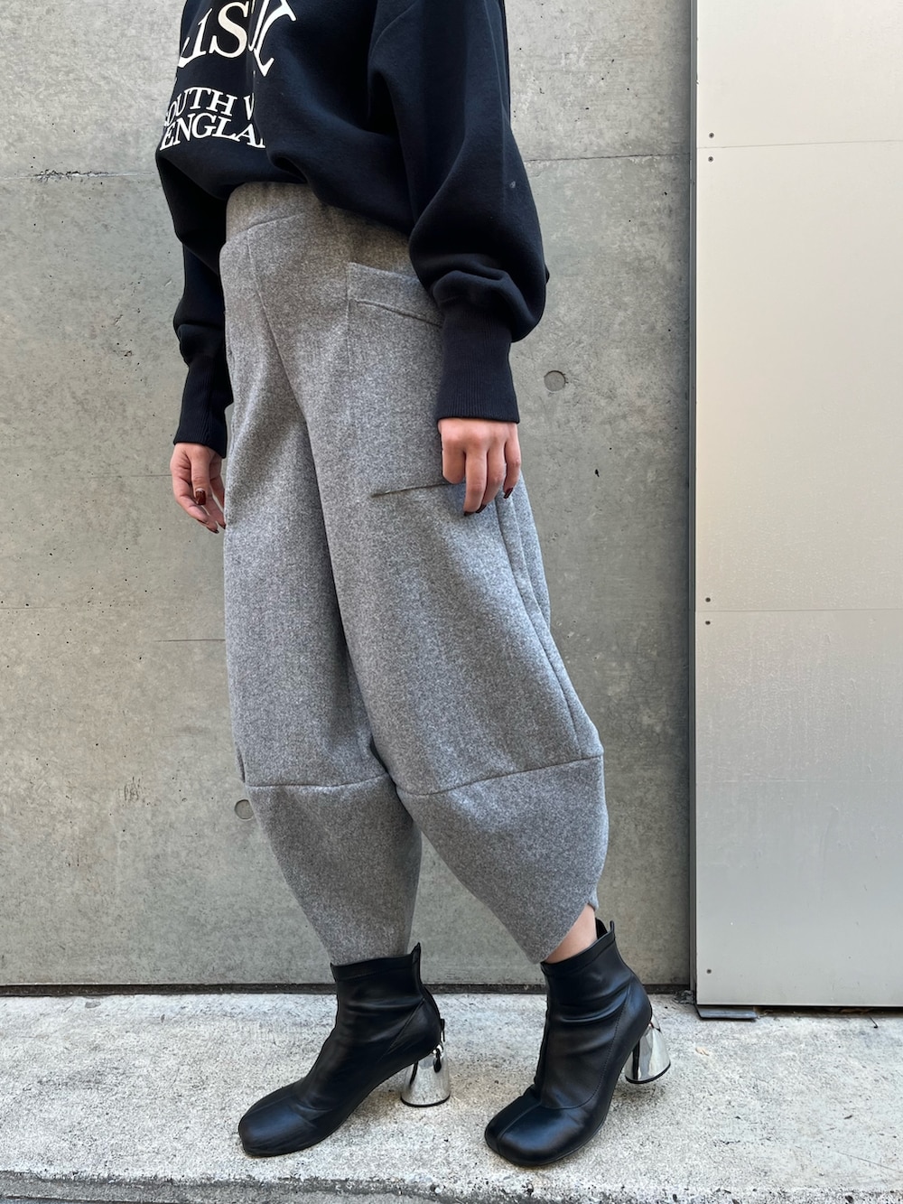 グレー系のその他パンツ、ブラック系のニット/セーター、ブラック系のハットを着用したレディースの冬コーディネートの6枚目の写真