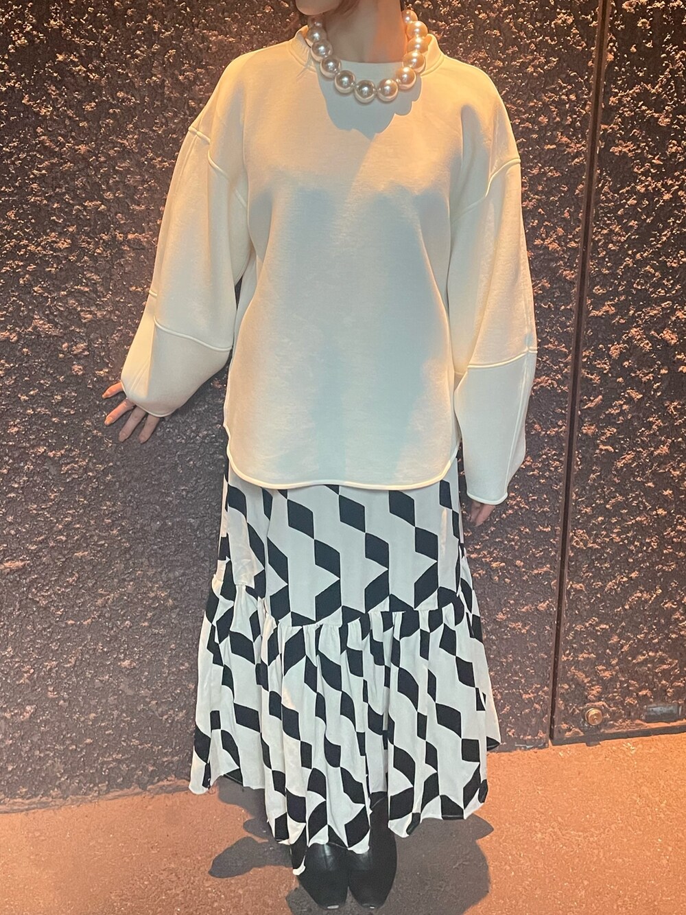 ベージュ系のスカート、ホワイト系のスウェット、その他のネックレスを着用したレディースの秋コーディネートの3枚目の写真