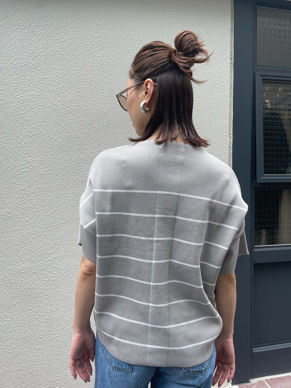 グレー系のTシャツ/カットソー、ブルー系のデニムパンツ、ブラウン系のサングラスを着用したレディースの夏コーディネートの4枚目の写真