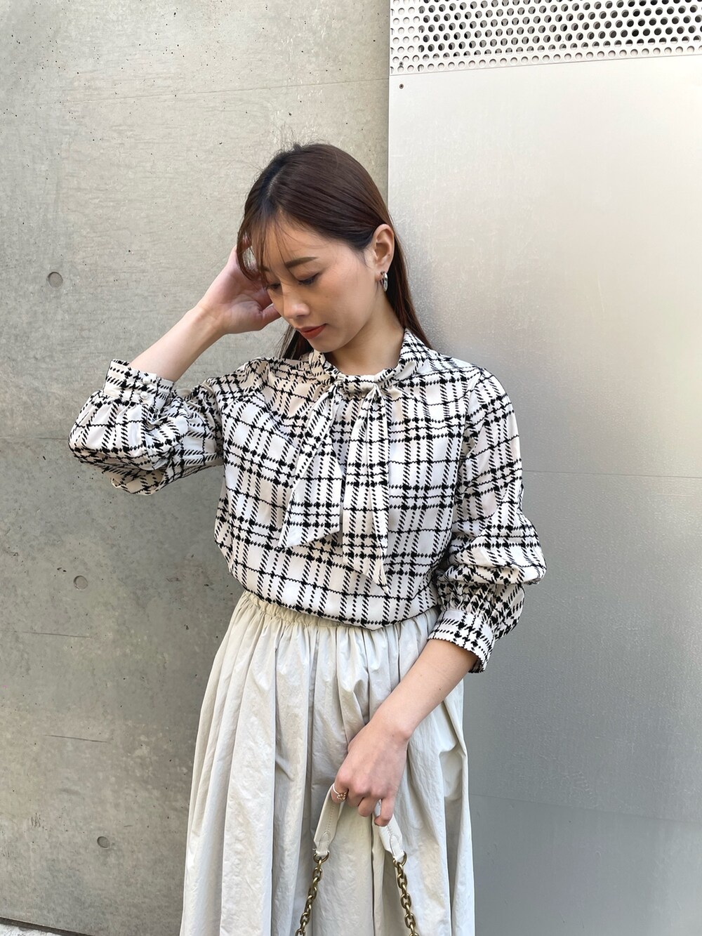 ホワイト系のハンドバッグ、グレー系のスカート、ホワイト系のシャツ/ブラウスを着用したレディースの冬コーディネートの3枚目の写真