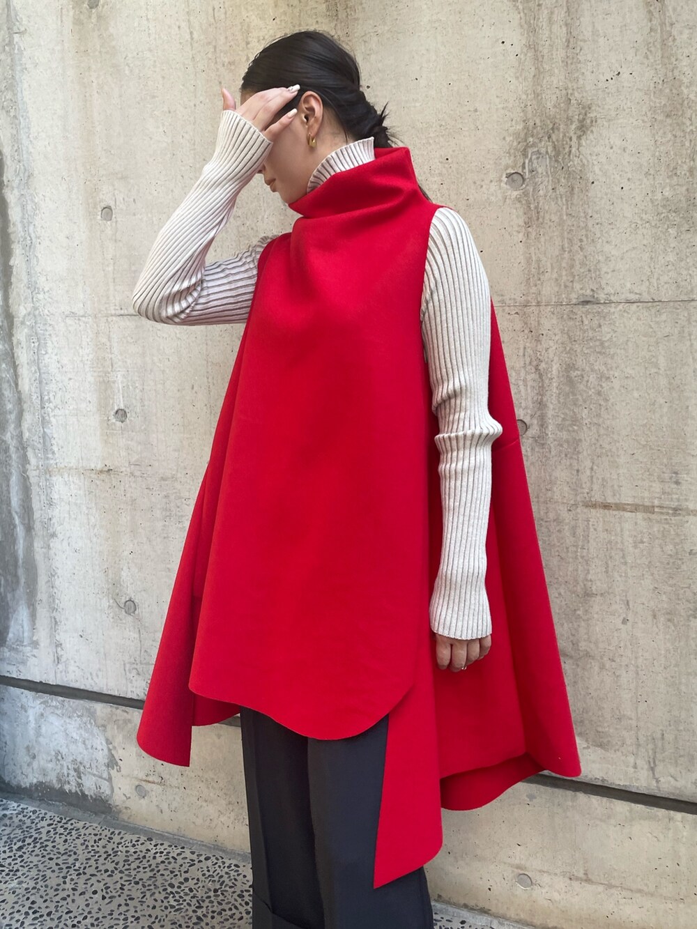 レッド系のベスト、ホワイト系のニット/セーター、ブラック系のその他パンツを着用したレディースの秋コーディネートの7枚目の写真