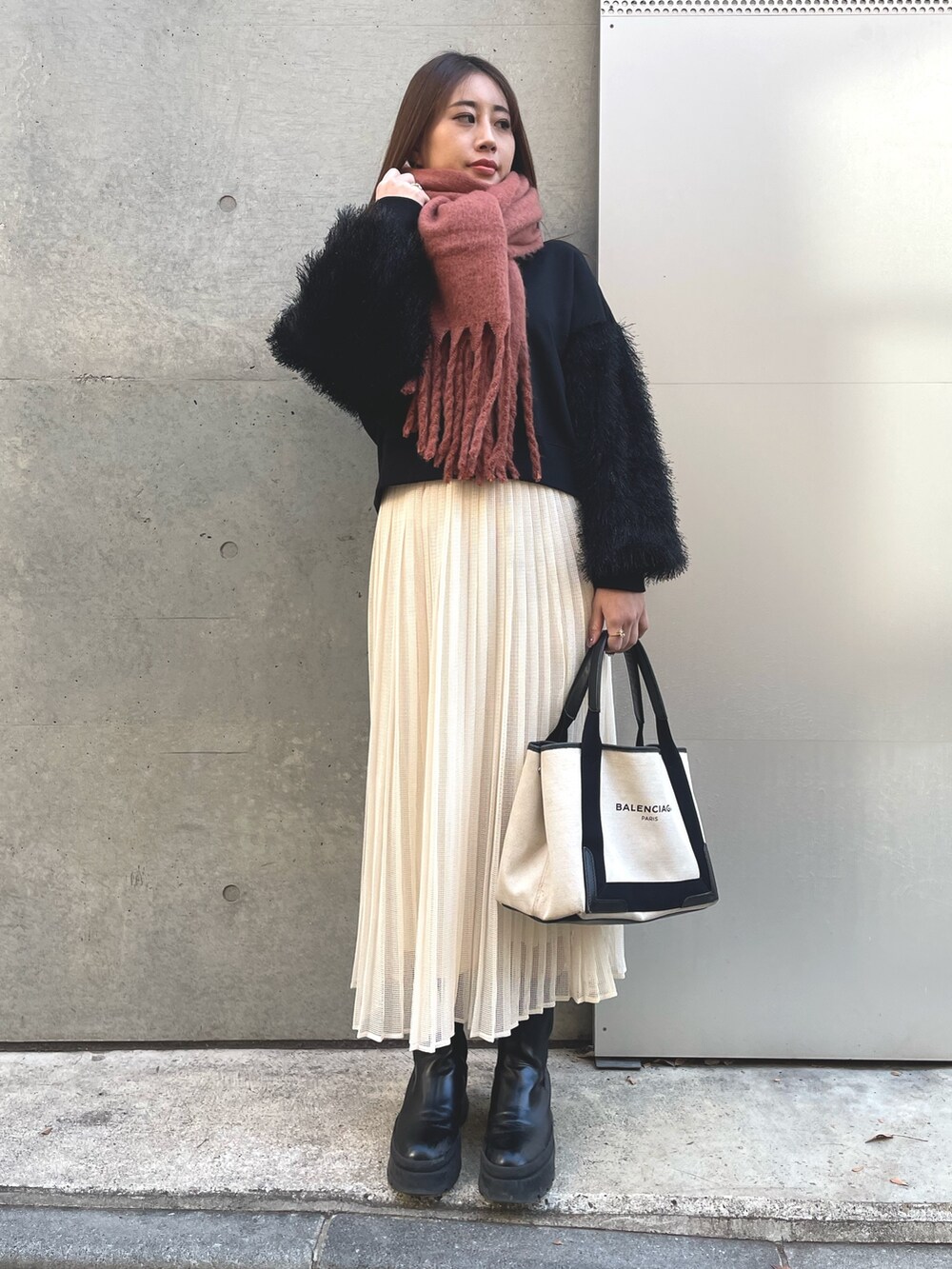 ホワイト系のスカート、ブラック系のスウェット、ベージュ系のトートバッグを着用したレディースの冬コーディネートの2枚目の写真