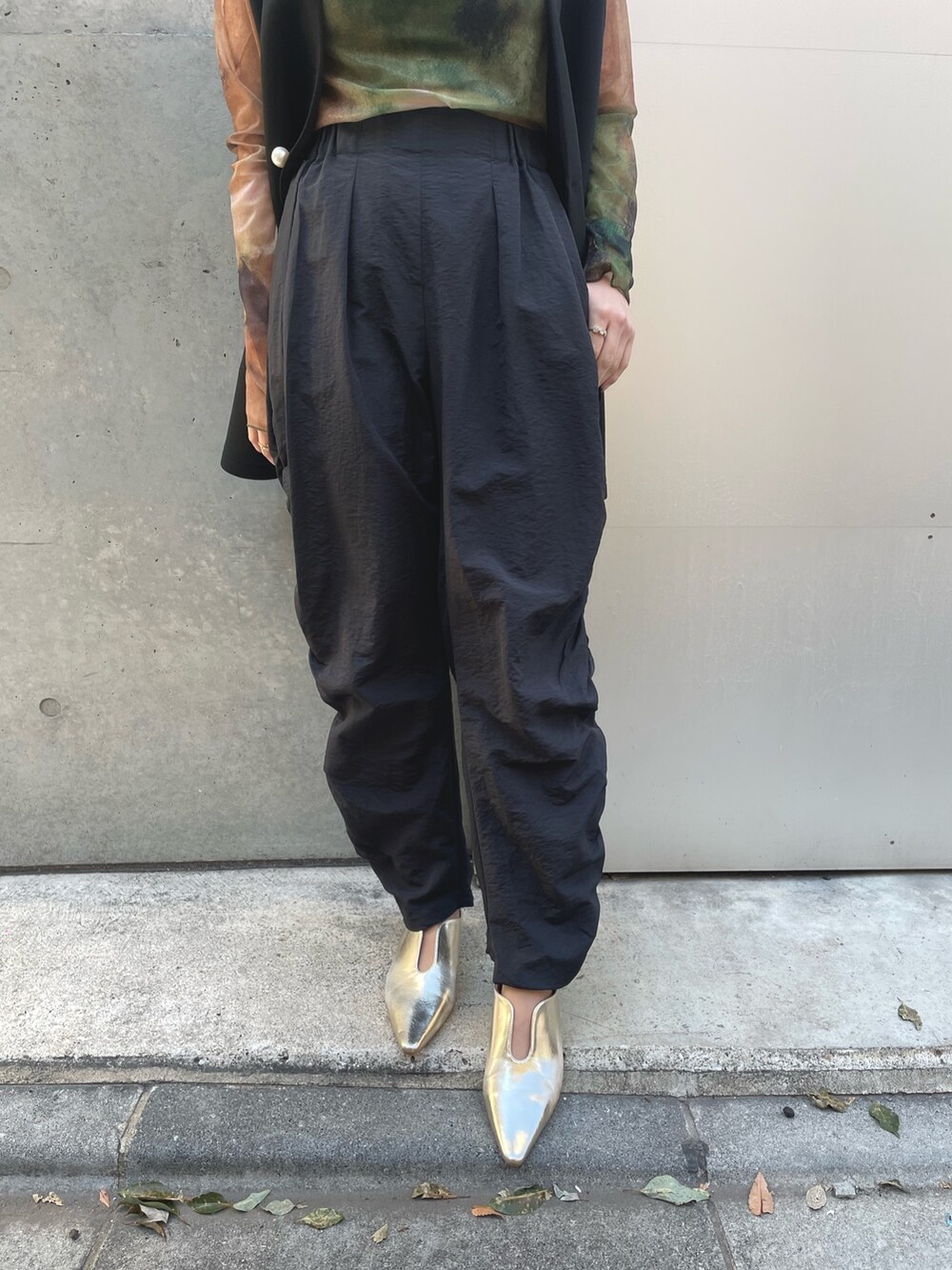 ブラック系のベスト、ブラック系のその他パンツ、グリーン系のTシャツ/カットソーを着用したレディースの春コーディネートの4枚目の写真