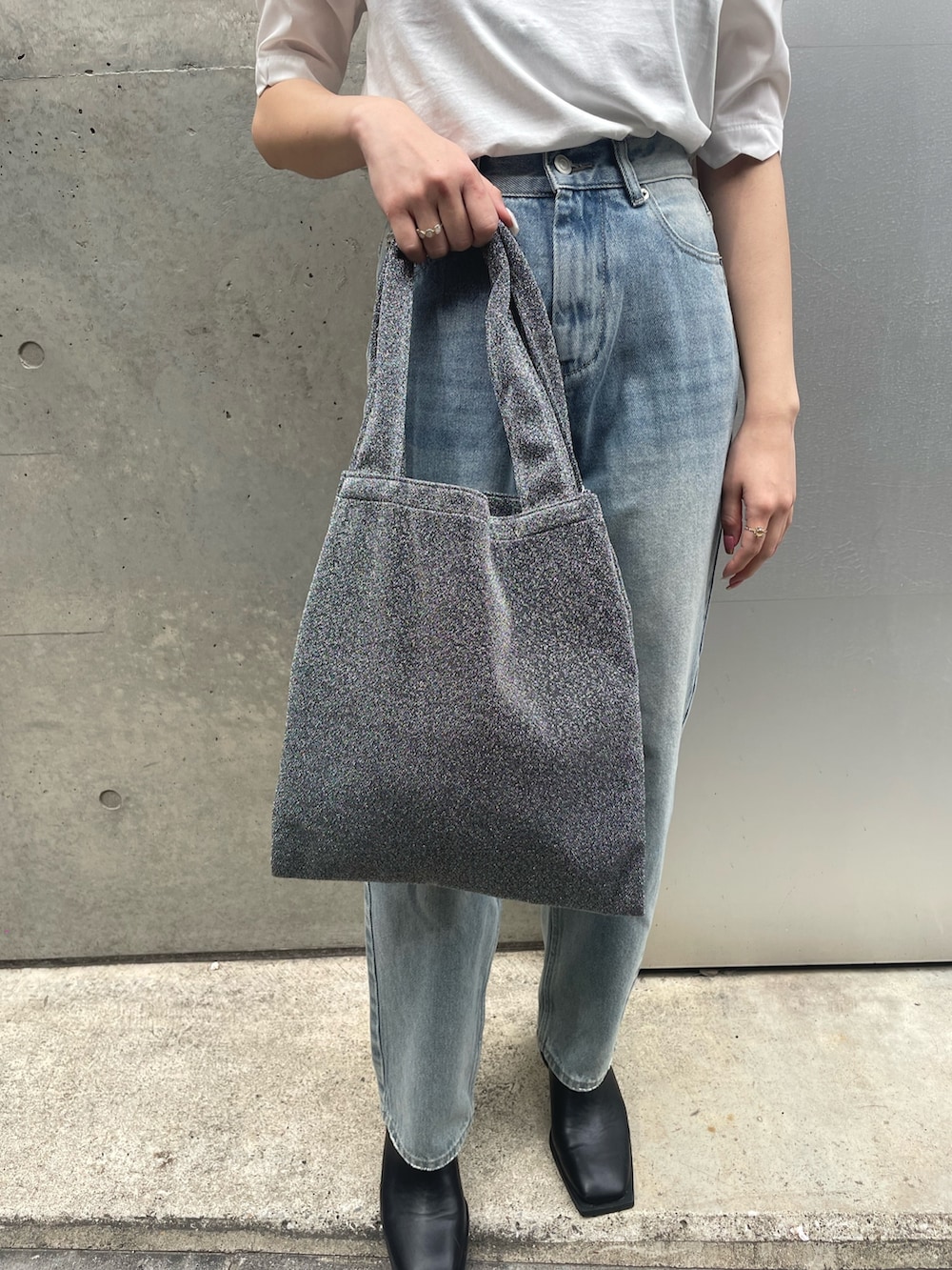 ホワイト系のTシャツ/カットソー、シルバー系のトートバッグ、ブルー系のデニムパンツを着用したレディースの春コーディネートの5枚目の写真