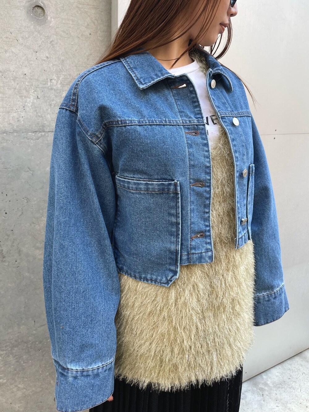 グリーン系のベスト、ブラック系のスカート、ブルー系のデニムジャケットを着用したレディースの冬コーディネートの4枚目の写真