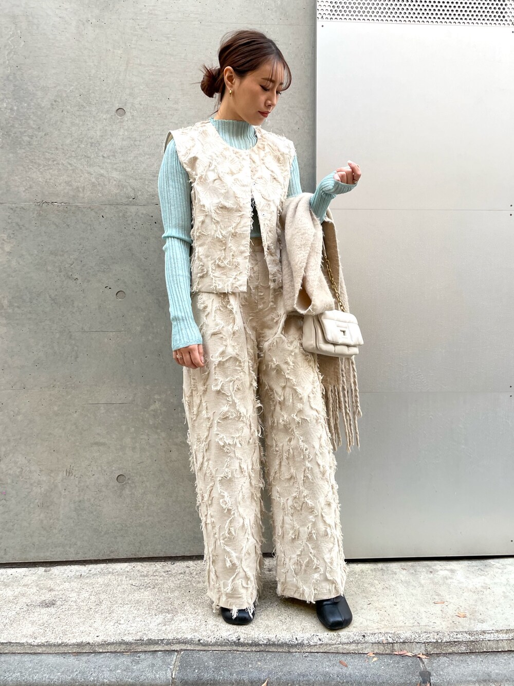 ホワイト系のその他パンツ、ホワイト系のベスト、グリーン系のTシャツ/カットソーを着用したレディースの冬コーディネートの2枚目の写真