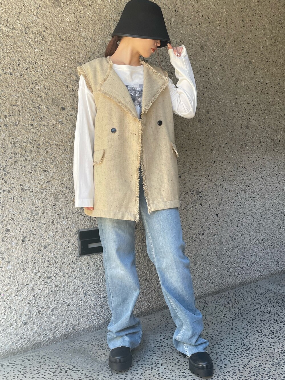 ベージュ系のベスト、ブラック系のハットを着用したレディースの冬コーディネートの3枚目の写真