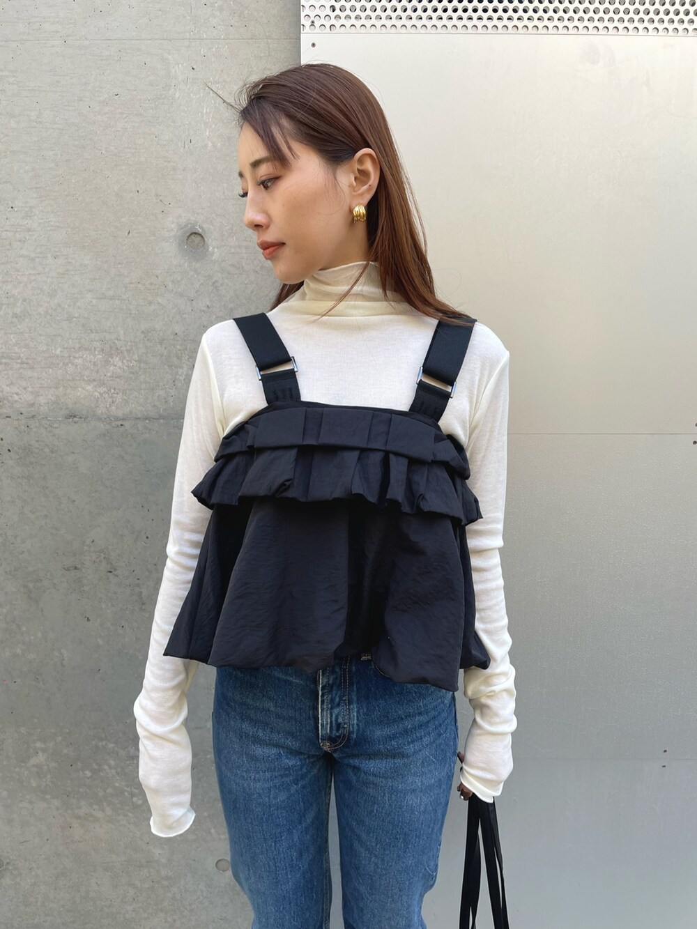 ホワイト系のTシャツ/カットソー、ブラック系のショルダーバッグ、ブラック系のベストを着用したレディースの春コーディネートの3枚目の写真