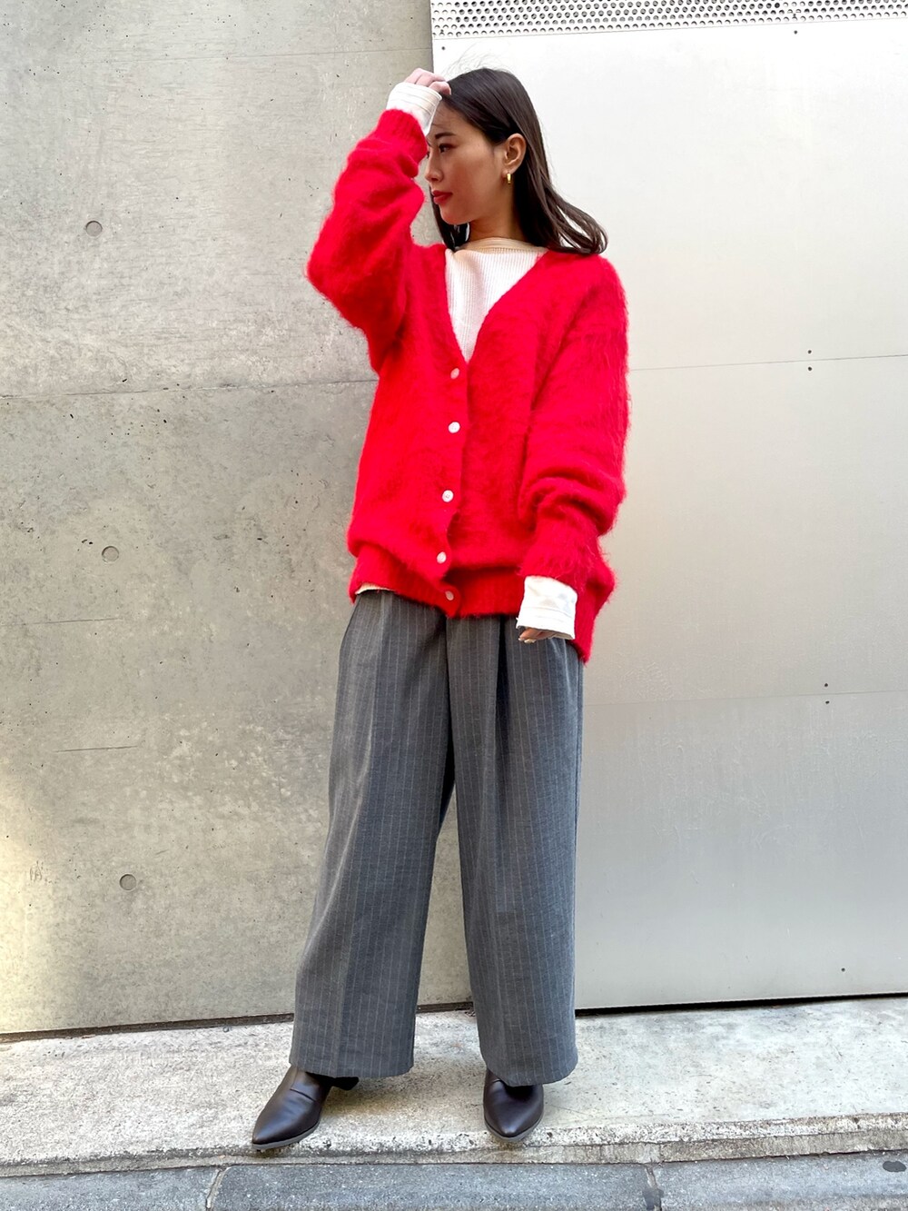 グレー系のその他パンツ、レッド系のカーディガン/ボレロを着用したレディースの冬コーディネートの3枚目の写真