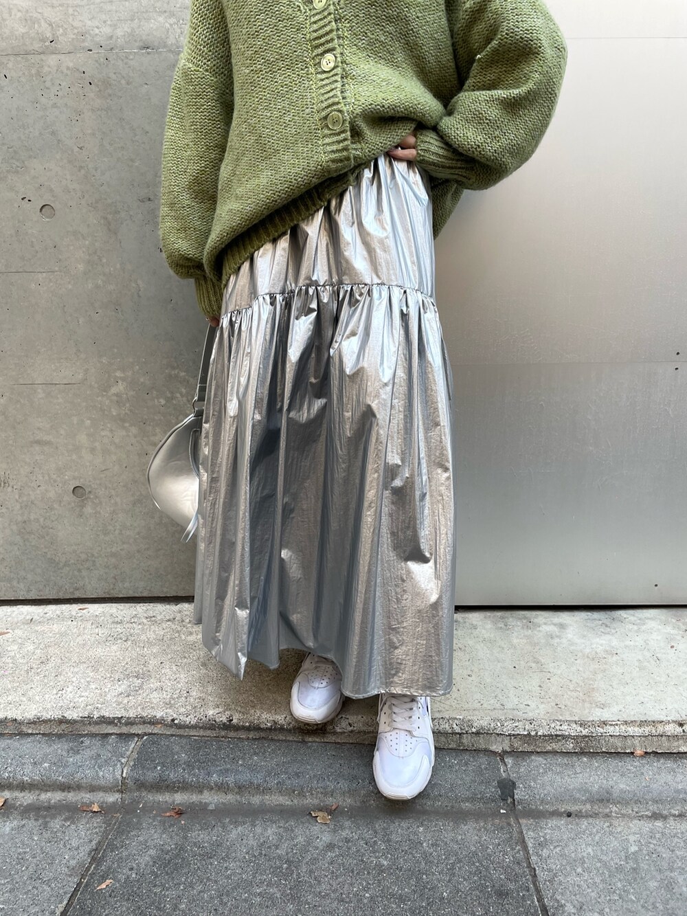 シルバー系のスカート、ホワイト系のスニーカー、ホワイト系のTシャツ/カットソーを着用したレディースの冬コーディネートの4枚目の写真