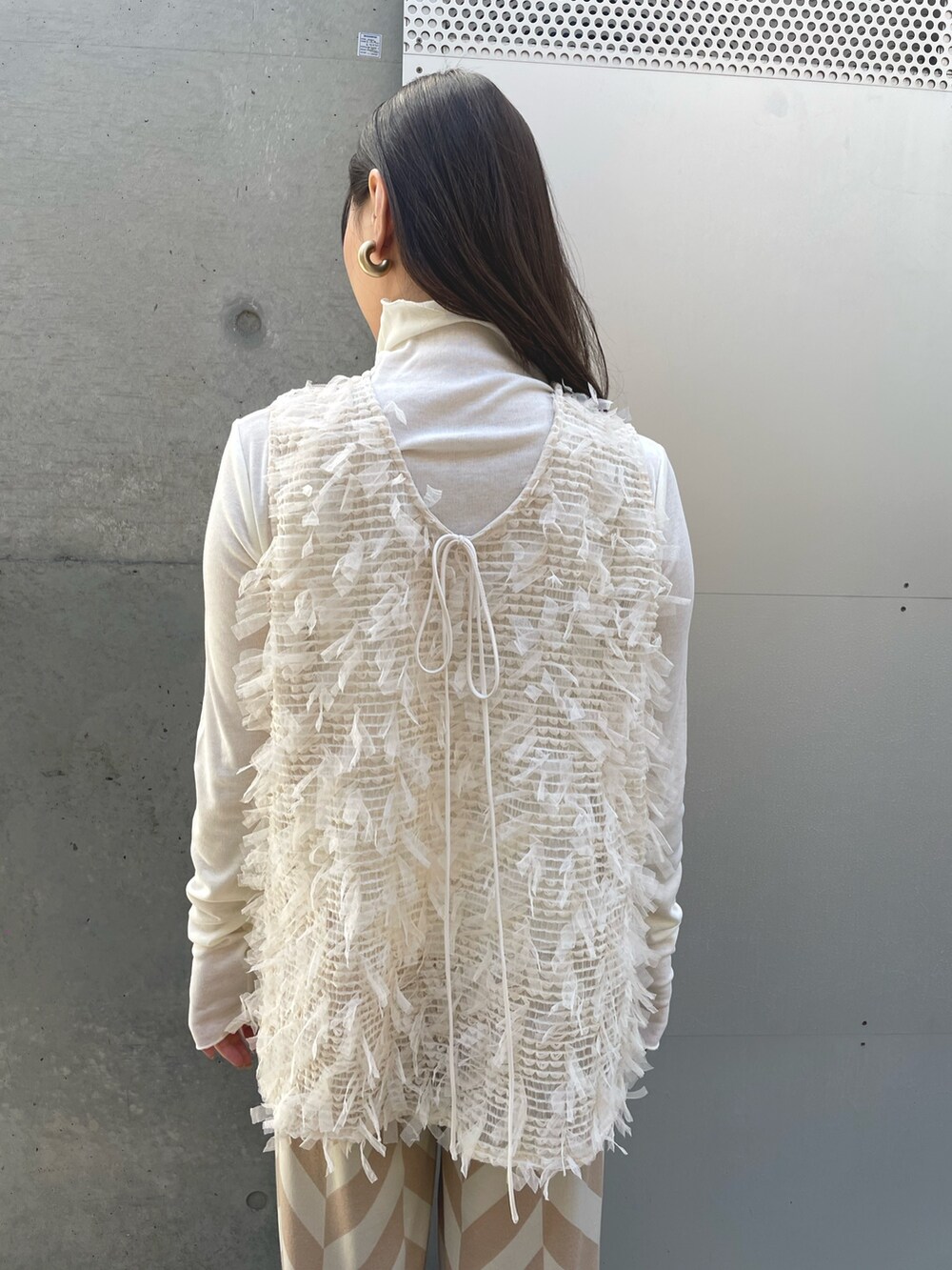 ホワイト系のTシャツ/カットソー、ホワイト系のベスト、ベージュ系のその他パンツを着用したレディースの春コーディネートの4枚目の写真