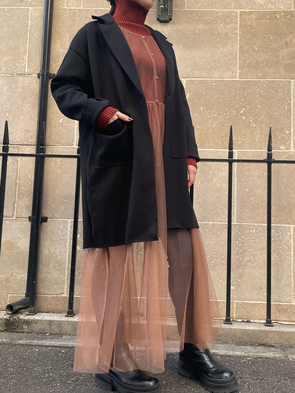 ベージュ系のワンピース、レッド系のニット/セーター、ブラック系のその他アウターを着用したレディースの秋コーディネートの6枚目の写真