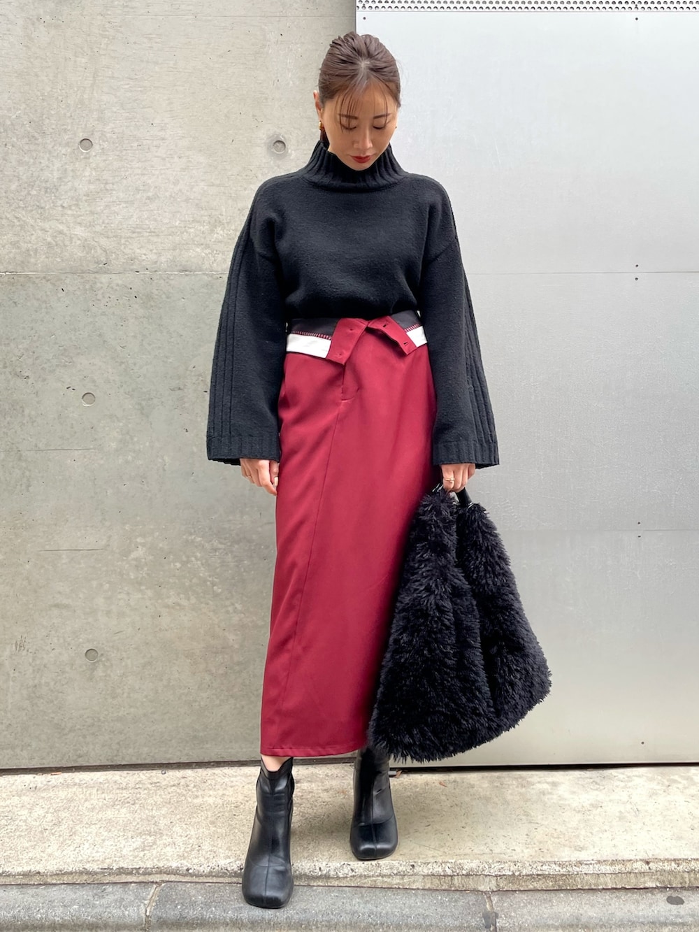 ブラック系のブーツ、レッド系のスカート、ブラック系のニット/セーターを着用したレディースの冬コーディネートの4枚目の写真