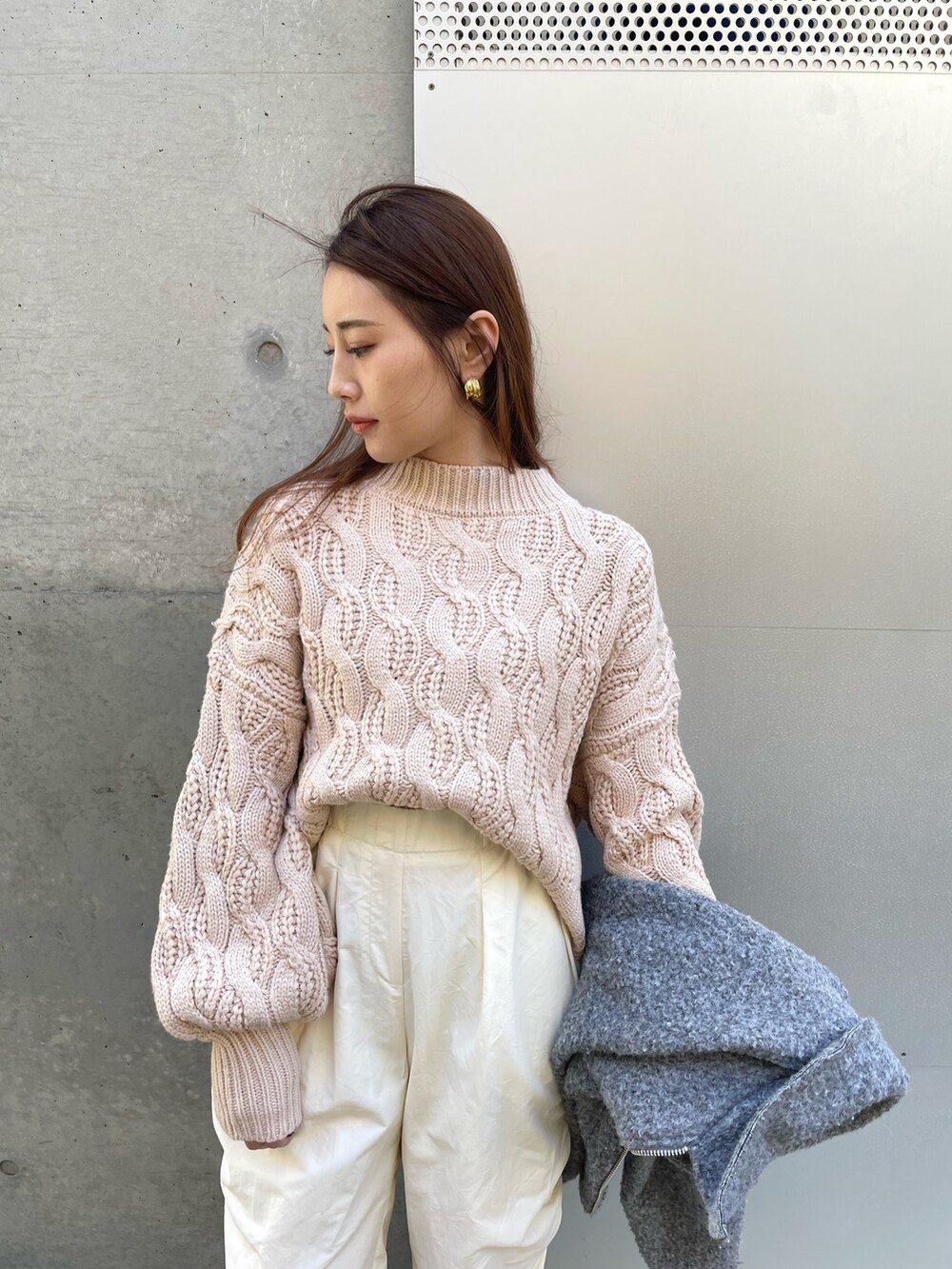 ベージュ系のニット/セーター、グレー系のジャケット/アウターを着用したレディースの春コーディネートの3枚目の写真