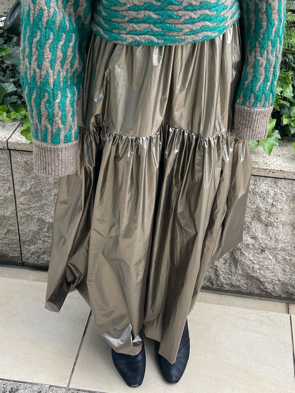 グリーン系のニット/セーター、ゴールド系のスカートを着用したレディースの秋コーディネートの7枚目の写真