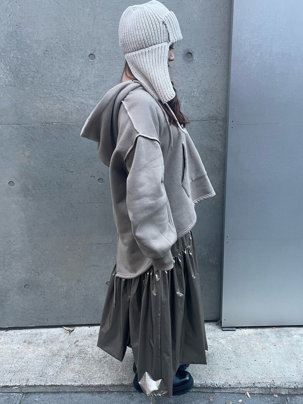 ゴールド系のスカート、ベージュ系のパーカー、ホワイト系のニットキャップ/ビーニーを着用したレディースの秋コーディネートの4枚目の写真