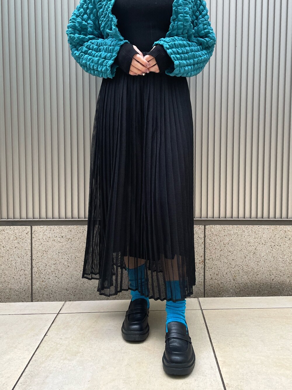 ブラック系のニット/セーター、ブルー系のカーディガン/ボレロ、ブラック系のスカートを着用したレディースの冬コーディネートの4枚目の写真