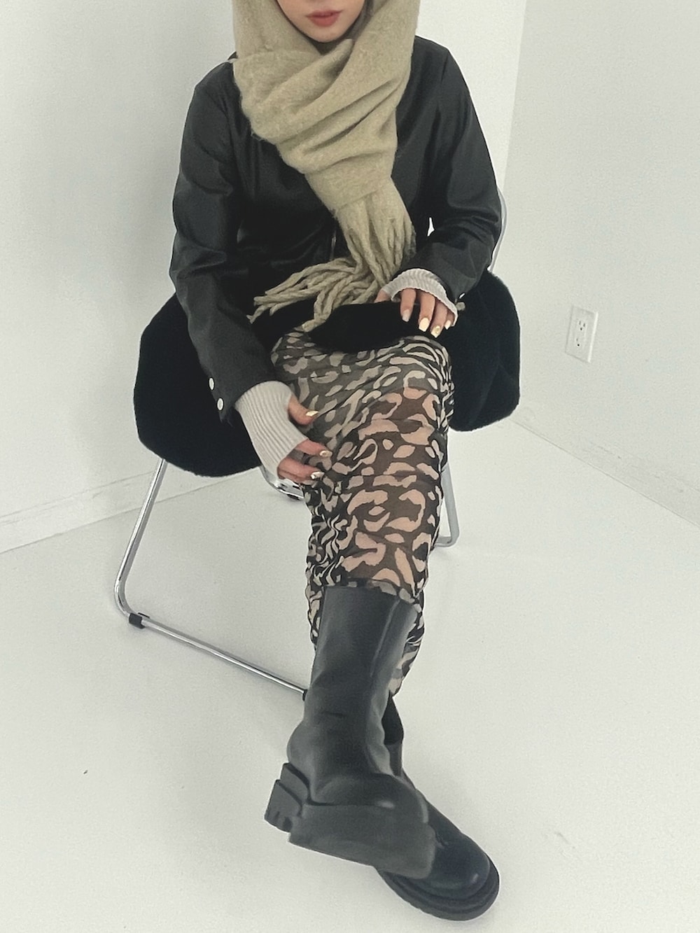 ブラック系のスカート、ベージュ系のストール/ショールを着用したレディースの冬コーディネートの6枚目の写真