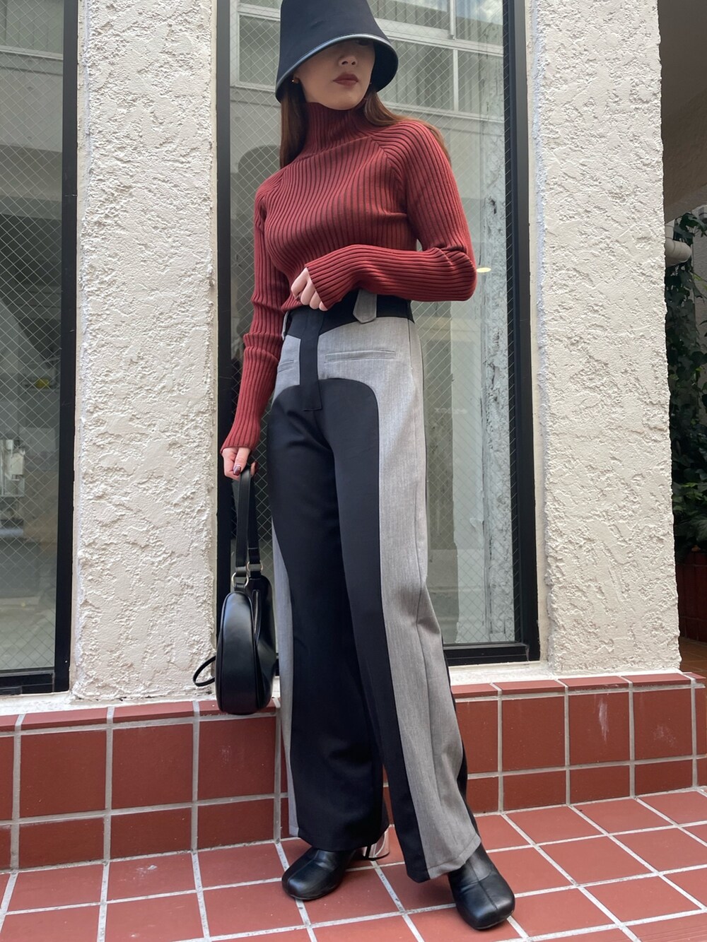 ブラック系のその他パンツ、ブラック系のショルダーバッグ、レッド系のニット/セーターを着用したレディースの冬コーディネートの3枚目の写真