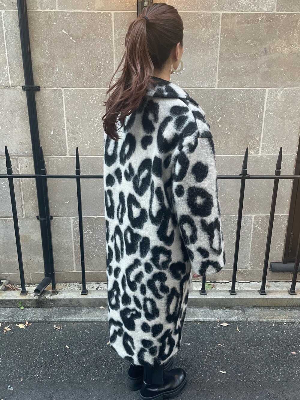 ベージュ系のチェスターコート、ゴールド系のピアス（両耳用）を着用したレディースの秋コーディネートの3枚目の写真