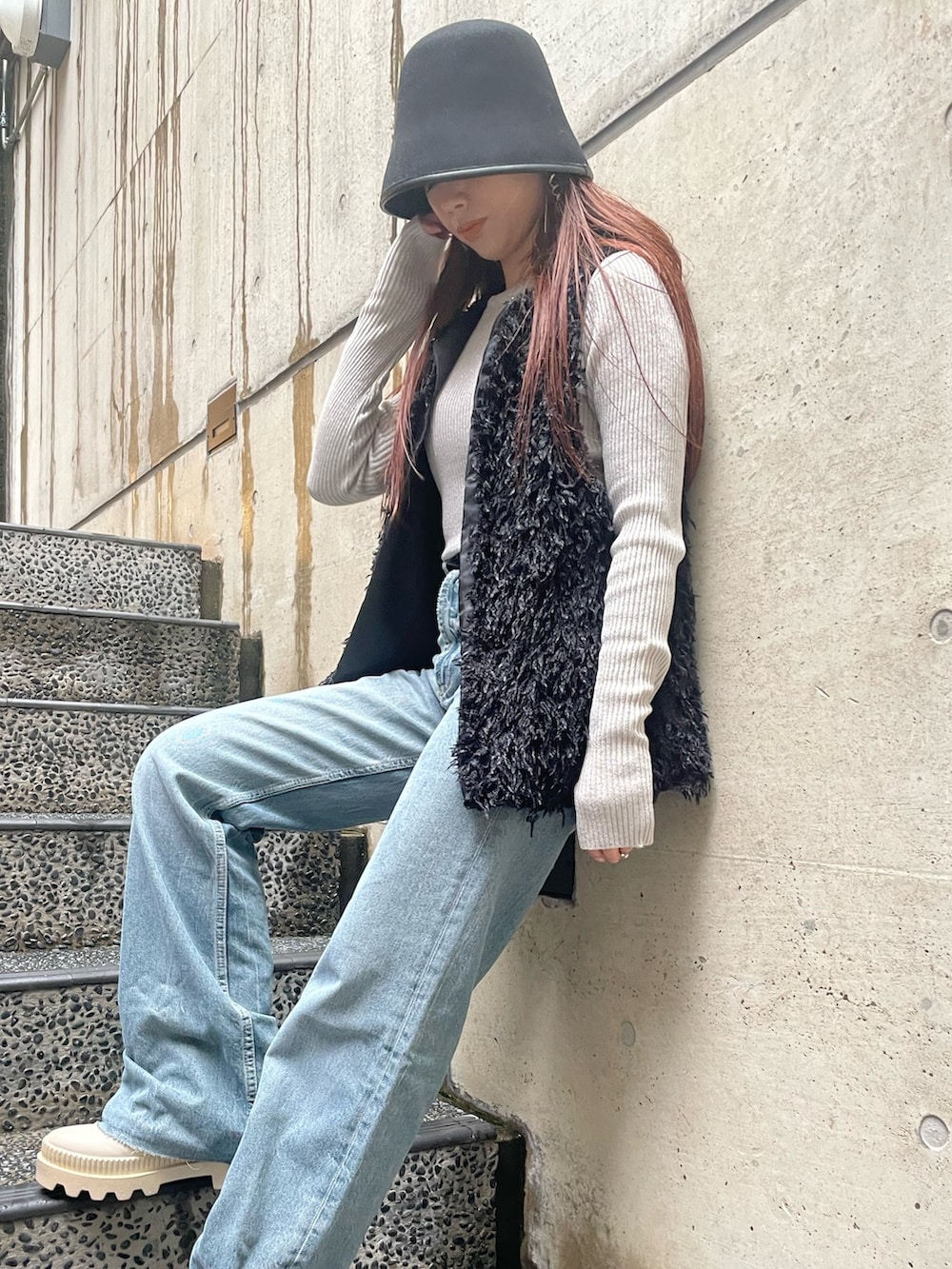 ブラック系のベスト、ホワイト系のニット/セーター、ブラック系のハットを着用したレディースの冬コーディネートの4枚目の写真