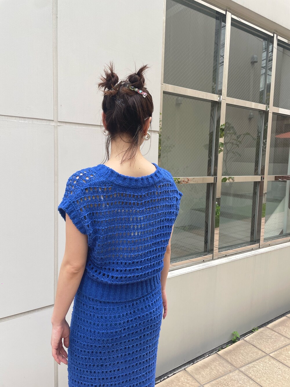 ブルー系のスカート、ブルー系のベスト、ホワイト系のスニーカーを着用したレディースの春コーディネートの4枚目の写真