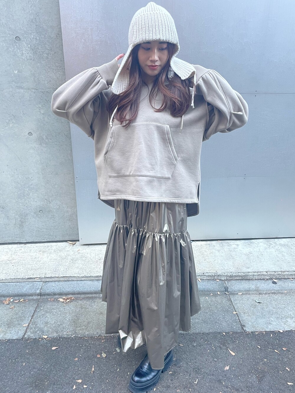 ゴールド系のスカート、ベージュ系のパーカー、ホワイト系のニットキャップ/ビーニーを着用したレディースの秋コーディネートの6枚目の写真