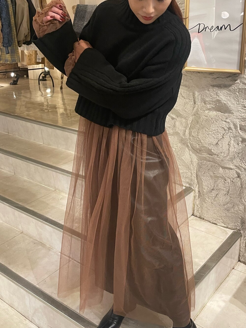 ベージュ系のワンピース、ブラック系のニット/セーターを着用したレディースの秋コーディネートの5枚目の写真