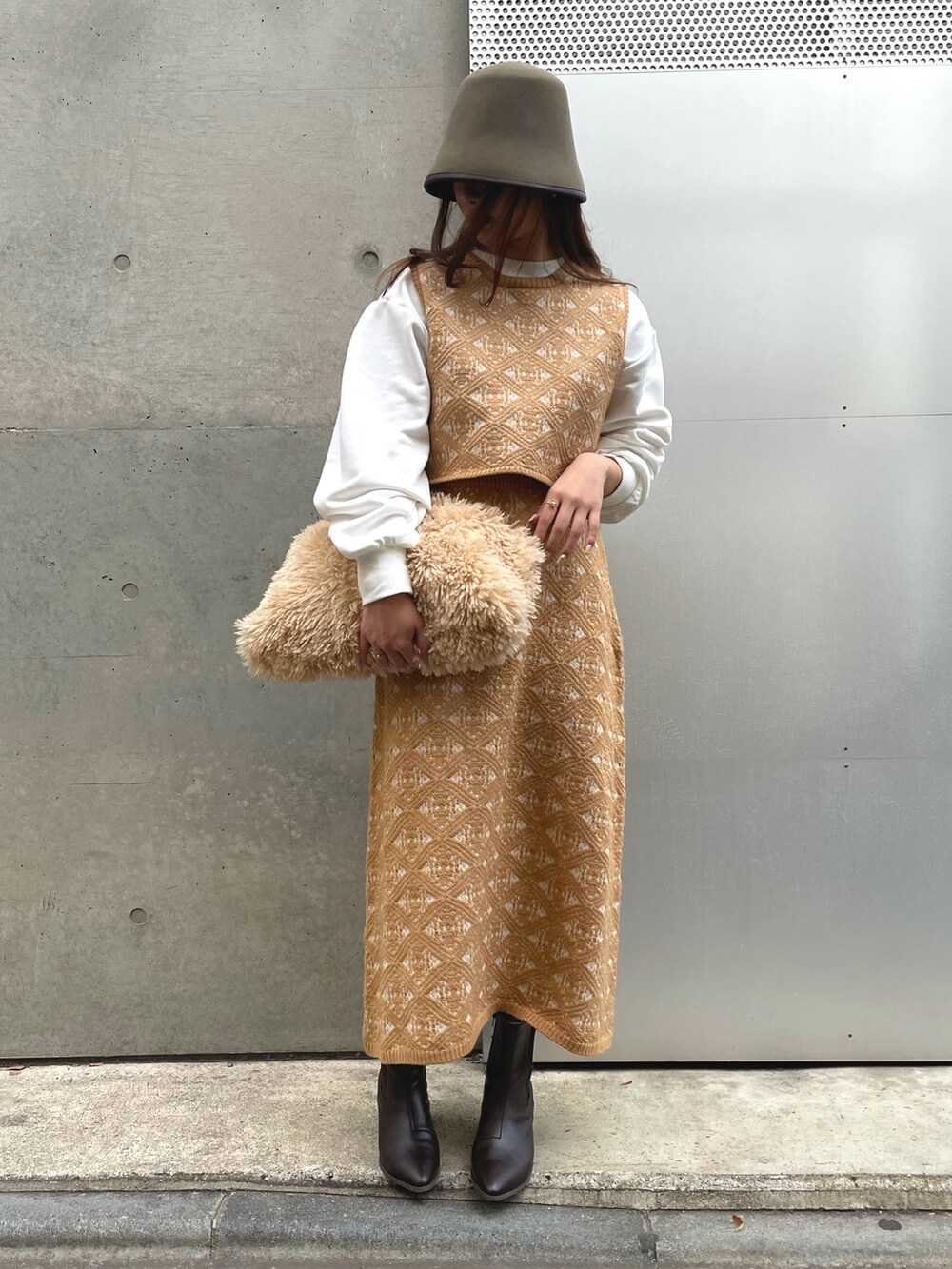 ベージュ系のトートバッグ、ベージュ系のスカート、グリーン系のハットを着用したレディースの冬コーディネートの5枚目の写真