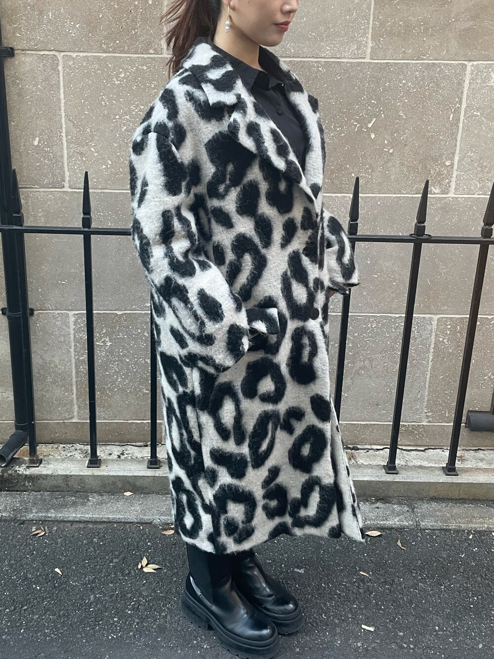 ベージュ系のチェスターコート、ゴールド系のピアス（両耳用）を着用したレディースの秋コーディネートの2枚目の写真