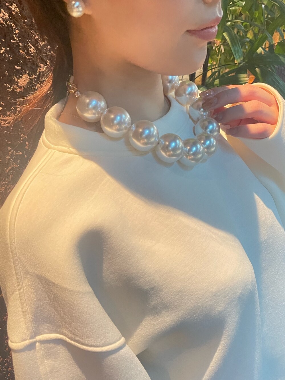 ベージュ系のスカート、ホワイト系のスウェット、その他のネックレスを着用したレディースの秋コーディネートの6枚目の写真